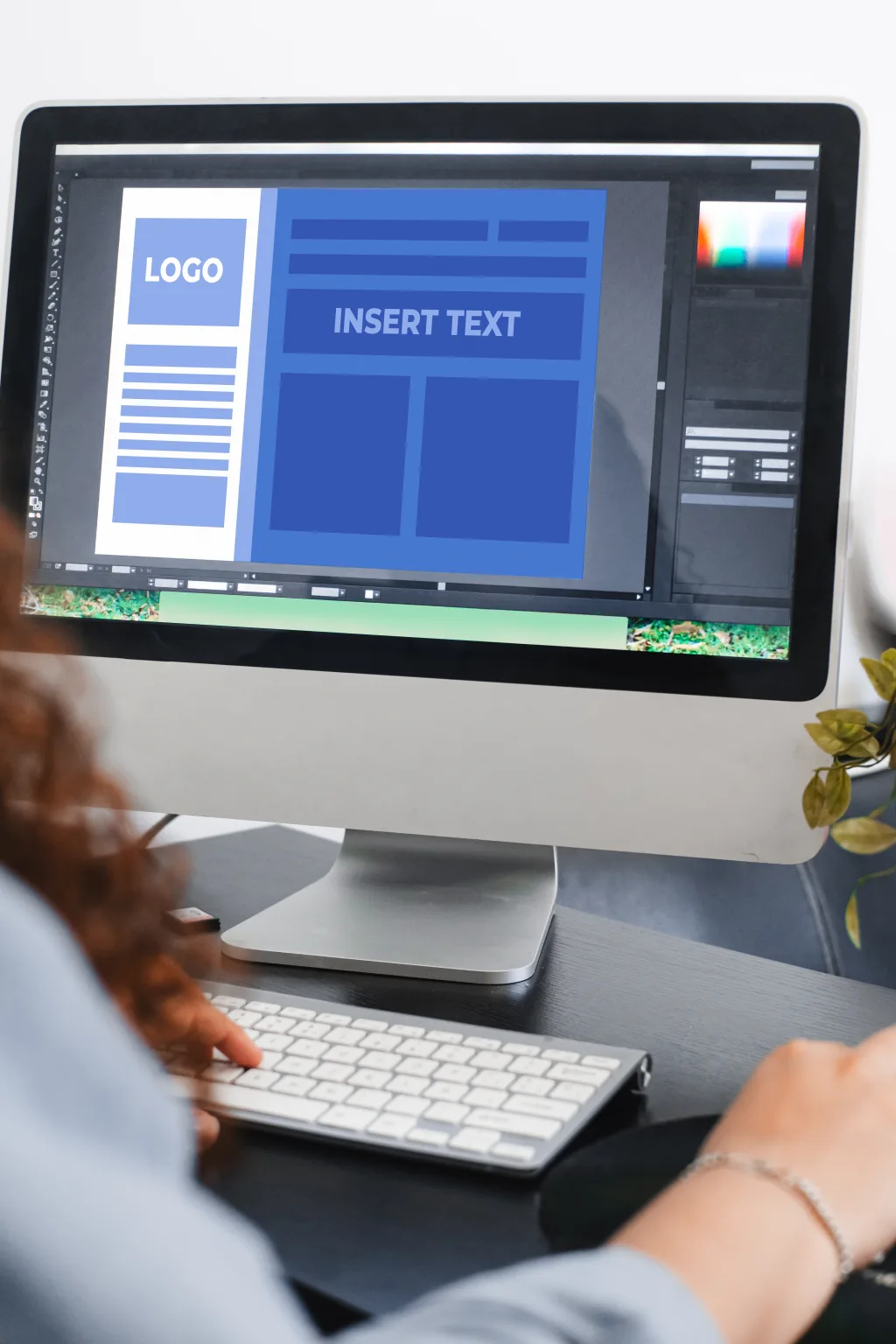 Designer drawing up a print design template at a workstation